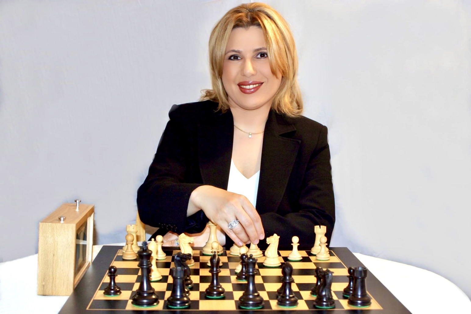 Mulher pondera o próximo movimento no jogo de xadrez, sentada em