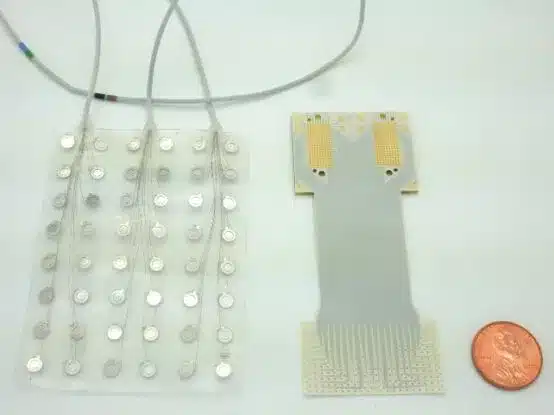 Próteses de fala atuais com 128 eletrodos (esquerda) e o novo dispositivo que acomoda o dobro de sensores em um conjunto significativamente menor. (Dan Vahaba/Universidade Duke)