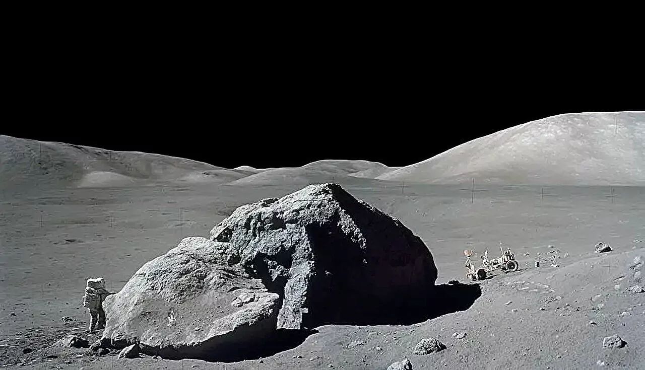 astronauta próximo de uma rocha lunar